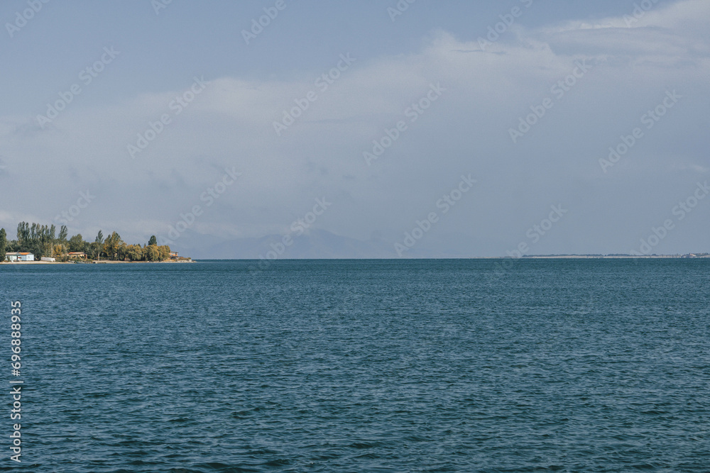view of sevan huge blue lake shore with mountain peaks far ahead