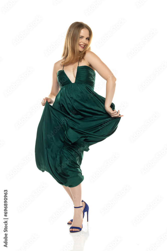Naklejka premium Full body front view portrait of elegant lovely blond lady dancing isolated on white background in green long dress
