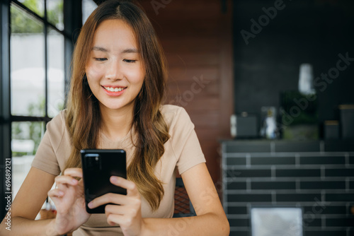 Asian young woman using smart phone for shopping online at cafe coffee shop in the morning  female has transfer money financial internet banking on mobile phone