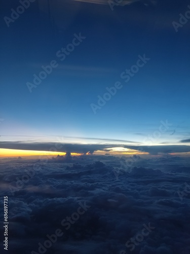 View from an airplane window. Sunrise above the clouds
