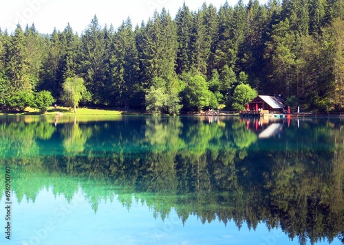 alpine landscape with lakes of crystal clear water and the reflection of the trees without people in summer