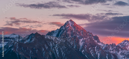 Close Up Colorado Mountain Peak with Vibrant Sunrise Purple Red Light at Dallas Divide. Snow Covered Mountain Peaks.