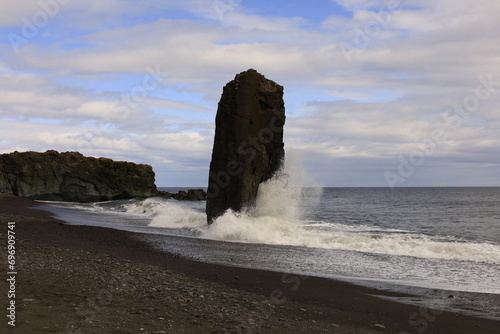 Fauskasandur is a hidden black sand beach in East Iceland characterized by a huge monolith on its shore photo