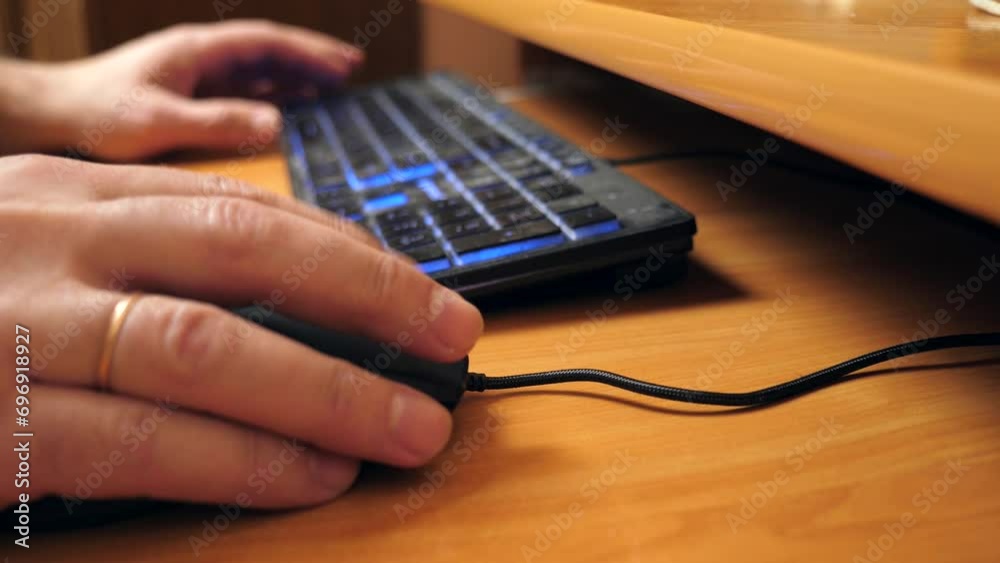 A person works at a computer using a mouse and keyboard. Slow motion.