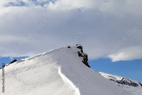 Top of mountains with snow cornice after snowfall