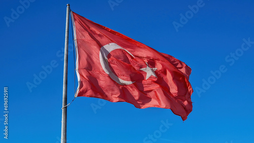 A closeup of the Turkish flag: Bold red and white, with the star and crescent, symbolizing unity and heritage.