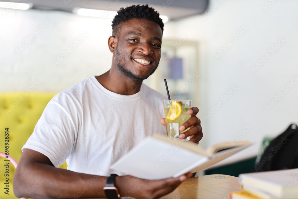 Clever young man, immersed in knowledge at a modern library, radiating positivity with a confident smile. Clever young man, immersed in knowledge at a modern library, radiating positivity with a confident smile.