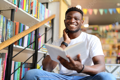 Happy young student in a library, surrounded by books and knowledge, exuding academic joy. photo