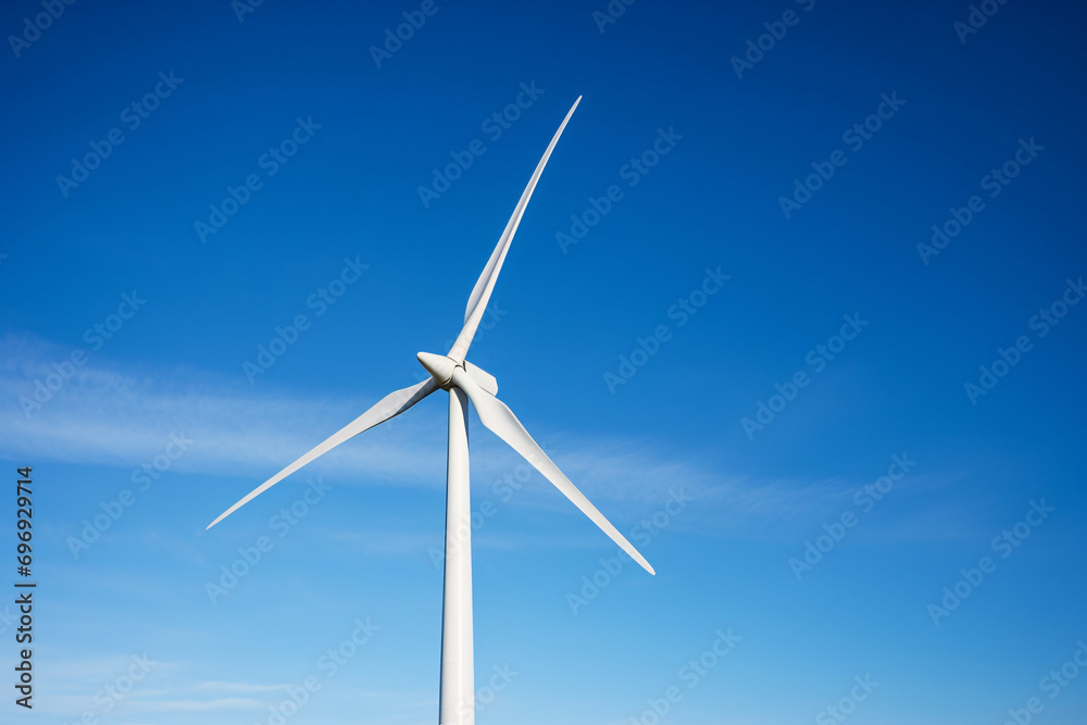 Close up of single wind mill turbine in front of blue sky Close up of single wind mill turbine in front of blue sky