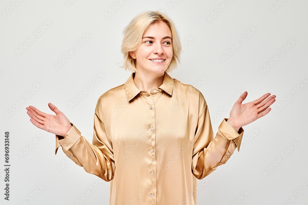 Young blond woman in casual holding something in hand, demonstrating empty space for product or text isolated on white studio background. Young blond woman in casual holding something in hand, demonstrating empty space for product or text isolated on white studio background.