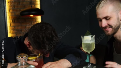 Tattooed man whispers gossip to close friend in dimly lit pub. Mates spread rumours enjoying pleasant atmosphere at bar counter photo