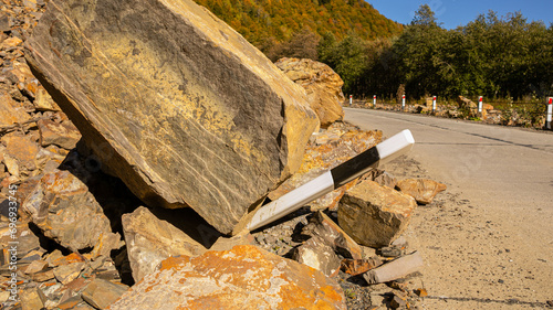 Obraz na plátně A large boulder crushing a guardrail on a mountain road, illustrating a concept