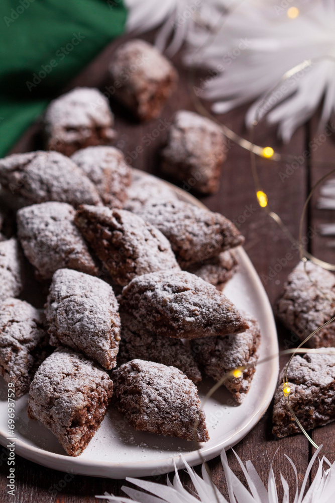 Italian Christmas cookies Castagnelle with almonds, cocoa and egg whites on a wooden background. Gluten free cookies.