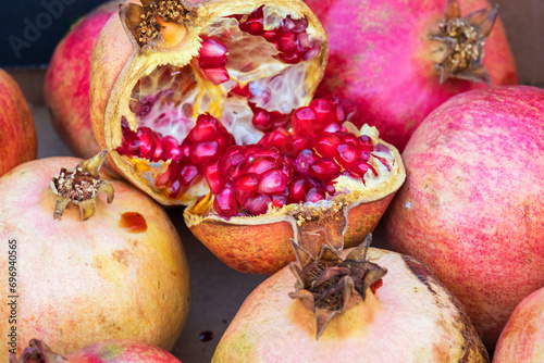 Several ripe pomegranate fruits and an open pomegranate, pomegranate on street market. Fresh ripe pomegranate, selective focus, Healthy pomegranates fruit garn photo