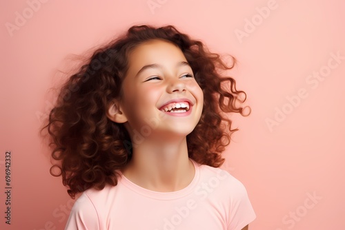 A cute and beautiful young female model with a joyful smile  radiating happiness and charm  against a solid light pink background.