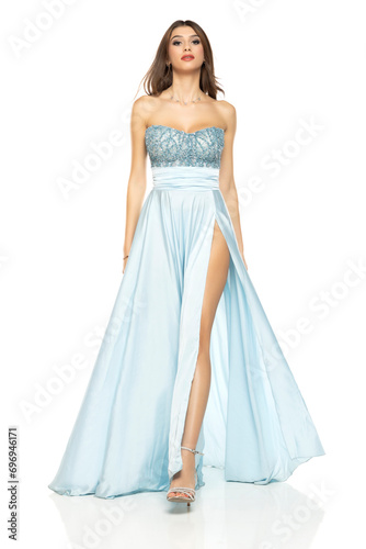 Full length of gorgeous elegant sensual brunette woman walking in blue evening dress isolated on white studio background