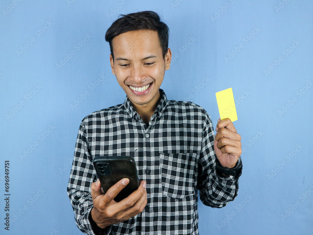 Happy expression handsome asian man hold paper money banknotes and empty card.