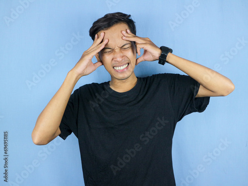 Handsome young man Hands holding head suffering from headache because pain and migraine. photo