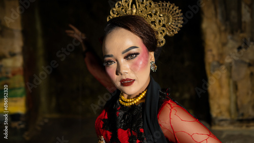 an Indonesian dancer with facial expressions that radiate beauty and happiness dances and captivates the audience photo