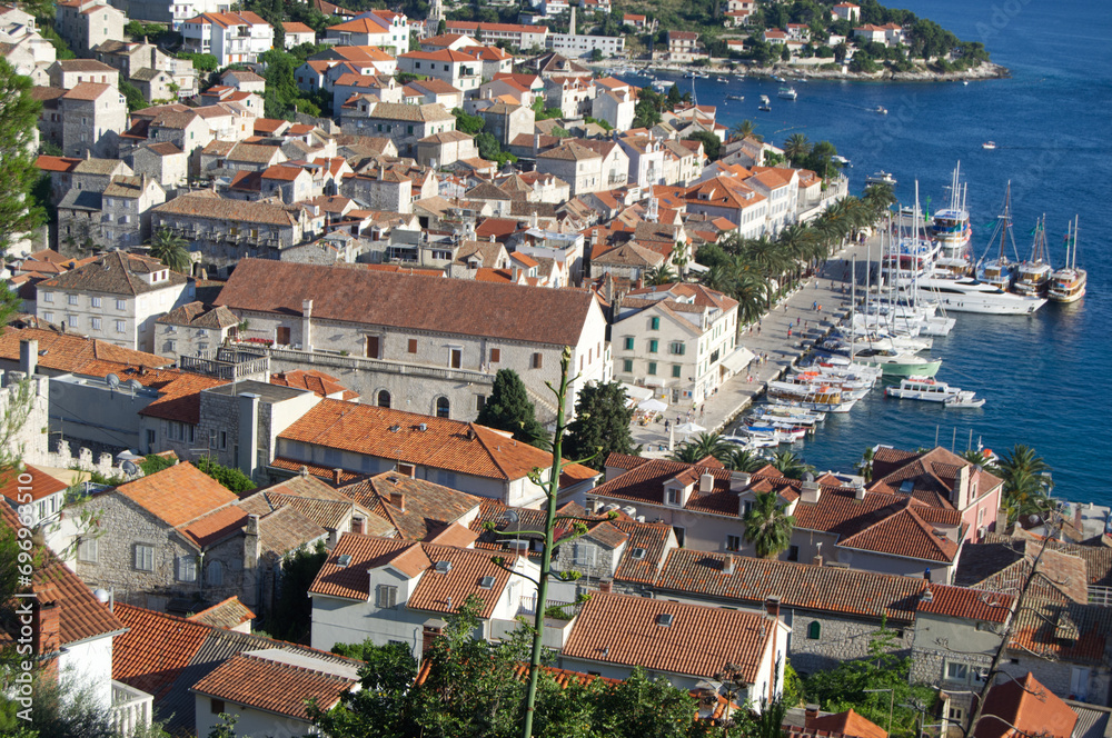 historic stone buildings in Hvar, Croatia iwith harbor and boats seen from hill