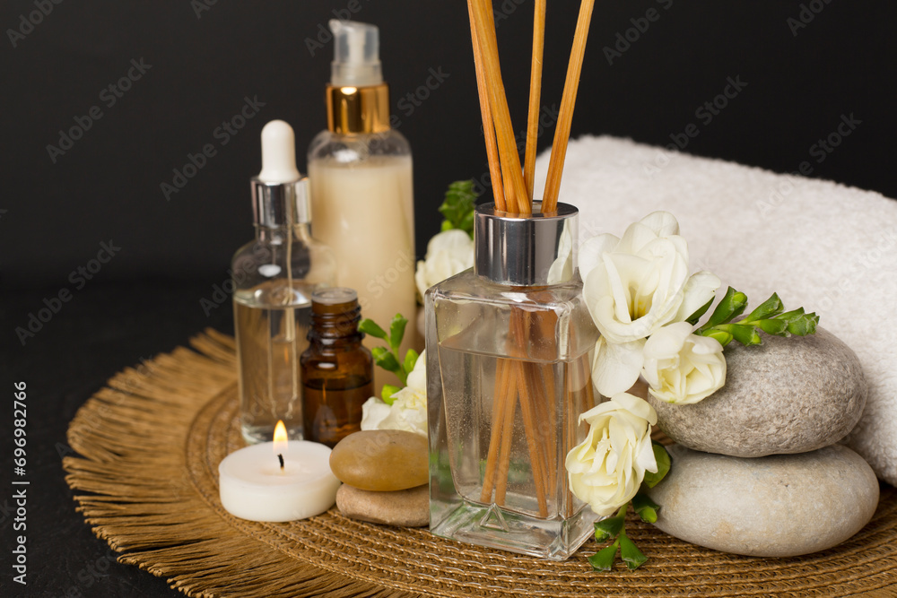 Spa composition with freesia flower and aroma diffuser on concrete background Spa composition with freesia flower and aroma diffuser on concrete background