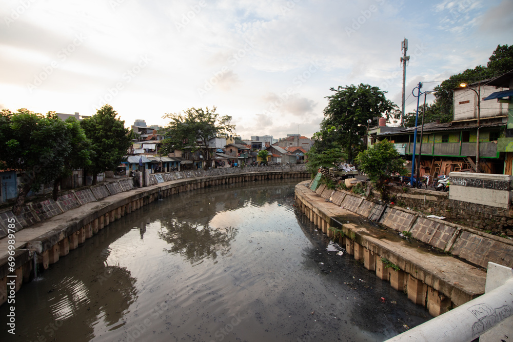 Urban river with surrounding residential area under an overcast sky