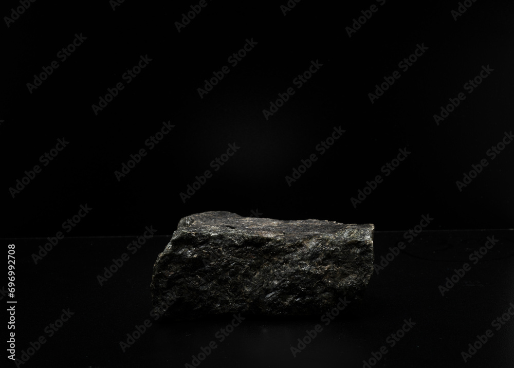 Fototapeta premium black natural stones on a black background for the podium