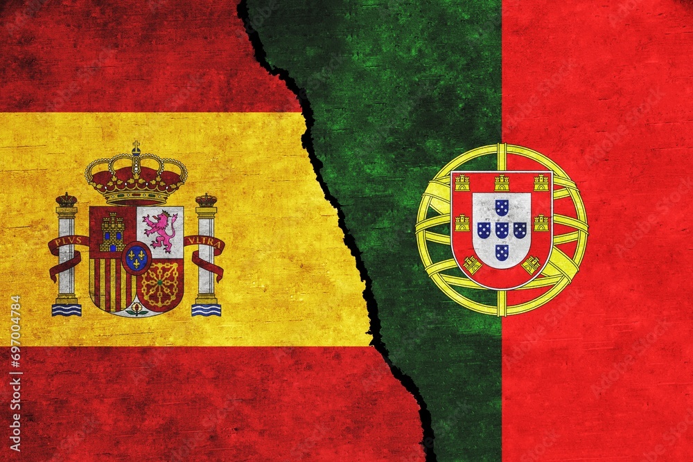 Fototapeta premium Spain and Portugal with painted flags on a wall with a crack. Relation between Spain and Portugal 
