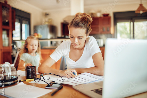 Stressed Mother Managing Finances and Work with Child at Home photo