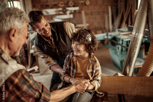 Three generations of men in a woodworking workshop