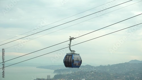 Blue funicular cable car offers a scenic touristic ride to reach destination, against sky background. Public transportation and recreational experience, perfect vacation photo