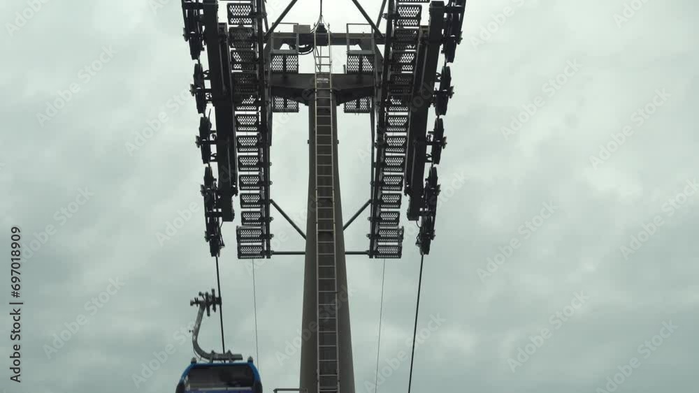 Funicular cable car cabin moves to destination, reaching the required point with ease. Recreational touristic experience against the overcast background. Tourist transportation on vacation