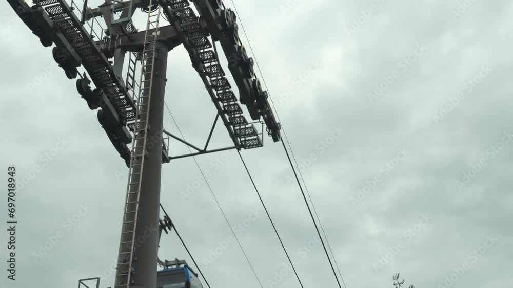 Funicular cable car cabin moves to destination, reaching the required point with ease. Recreational touristic experience against the overcast background. Tourist transportation on vacation