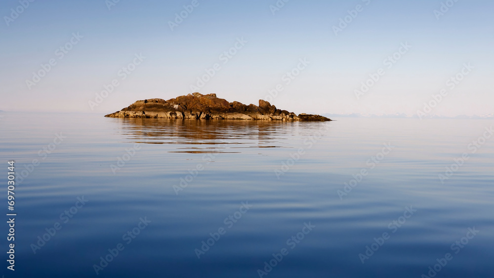 Calm sea and an islet in a warm summer day. Lofoten, Northern Norway.  - obrazy, fototapety, plakaty 