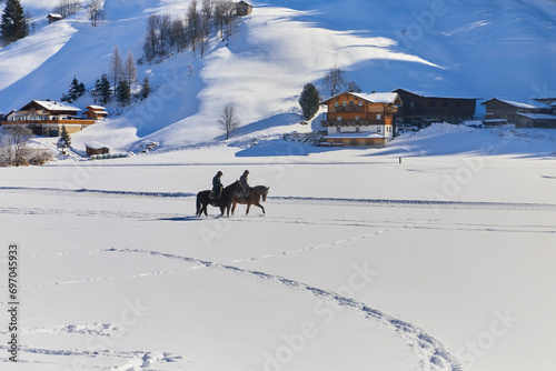 Schönes Winterpanorama mit zwei Reitern bei Bramberg am Wildkogel, im Salzburger Land, Österreich. © Composer