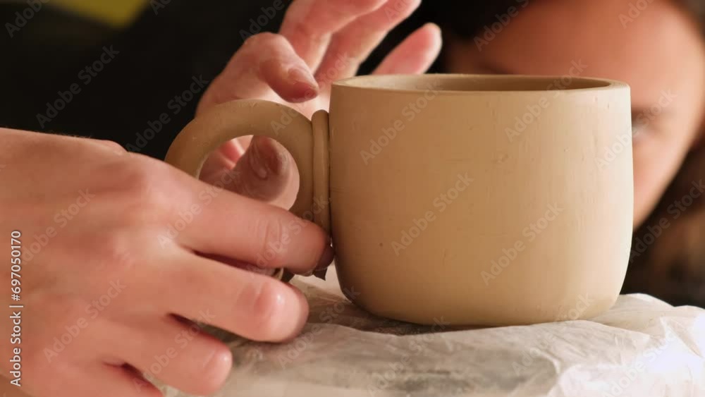 the potter makes a cup and a plate. women's hands make products from clay. the process of making dishes the potter makes a cup and a plate. women's hands make products from clay. the process of making dishes