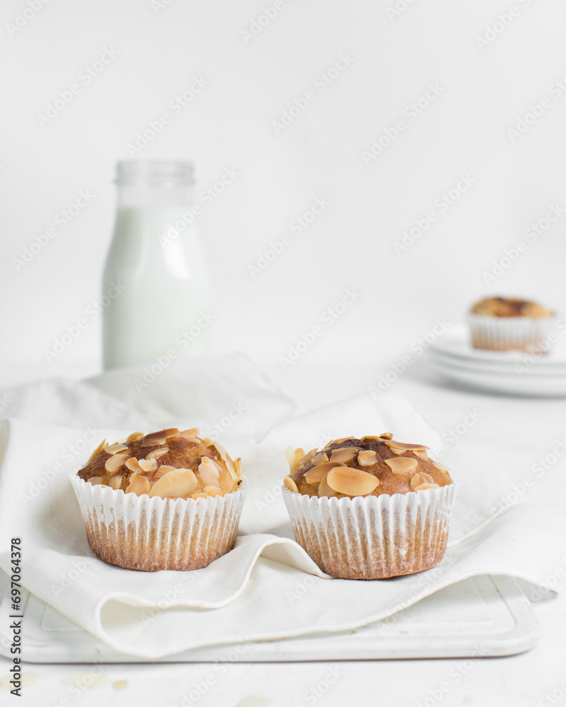 vanilla almond muffins on a white napkin, homemade bakery style almond muffins on a white background vanilla almond muffins on a white napkin, homemade bakery style almond muffins on a white background