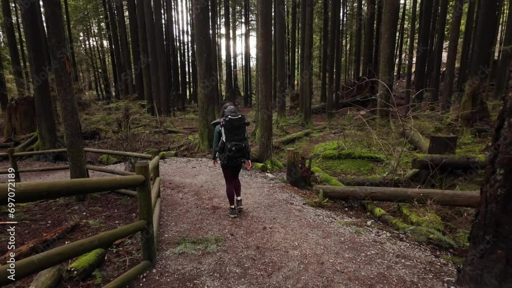 Mother Hiking with Baby Boy in Backpack Carrier in Canadian Nature. Fall Season, Daytime. North Vancouver, British Columbia Canada Mother Hiking with Baby Boy in Backpack Carrier in Canadian Nature. Fall Season, Daytime. North Vancouver, British Columbia Canada