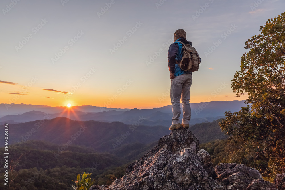 Hiker with backpack standing on top mountain sunset background. Hiker men's hiking living healthy active lifestyle.