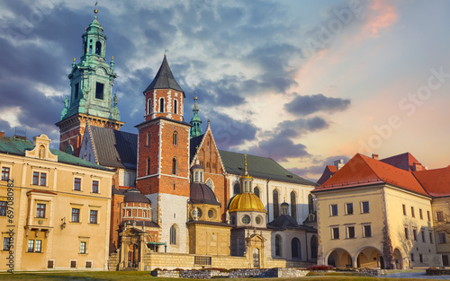 Wawel castle in Krakow, Poland. Towers of Catholic temple. Picturesque territory and buildings architecture. Winter day with evening warm sunshine lighting. Sky dramatic clouds photo