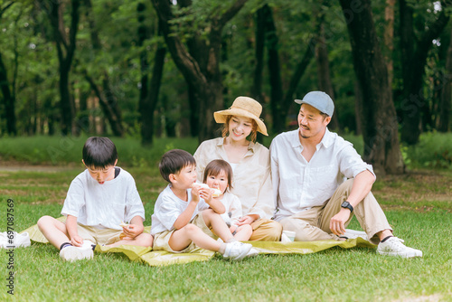夏休みにレジャー・ピクニックでランチを食べる家族・ファミリー・親子  © buritora