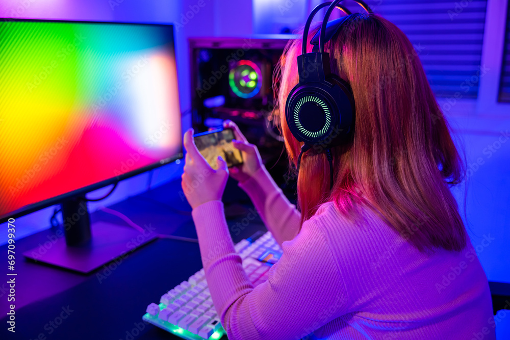 Asian woman live stream she play video game via smartphone at home neon lights living room, Gamer playing online game application on mobile phone wear gaming headphones, E-Sport concept Asian woman live stream she play video game via smartphone at home neon lights living room, Gamer playing online game application on mobile phone wear gaming headphones, E-Sport concept