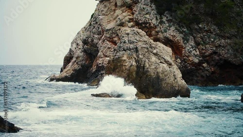 Waves crashing below Fort Bokar and Dubrovnik’s city walls on a cloudly day, Croatia. photo