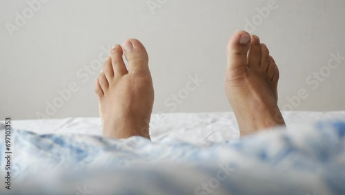  young Woman lying with bare feet in bed, photo