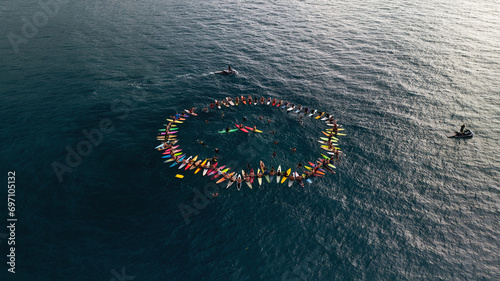 A group of surfers in a circle in the ocean in Hawaii