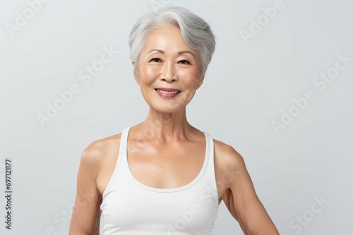 体を鍛えている日本人シニア女性（背景なし・筋トレ・筋肉・フィットネス・ヘルスケア）  photo
