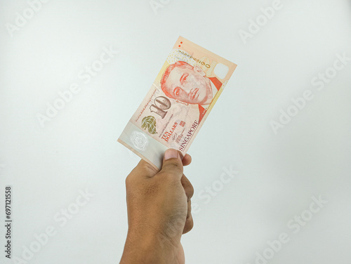 Hand hold a 10 singapore dollar banknote ready for shopping. Singapore currency a lot of value in shopping. photo