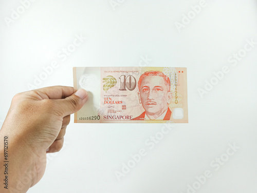 Photography Hand hold a 10 singapore dollar banknote ready for shopping