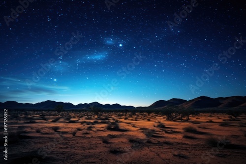 A night sky filled with stars over a tranquil desert landscape.