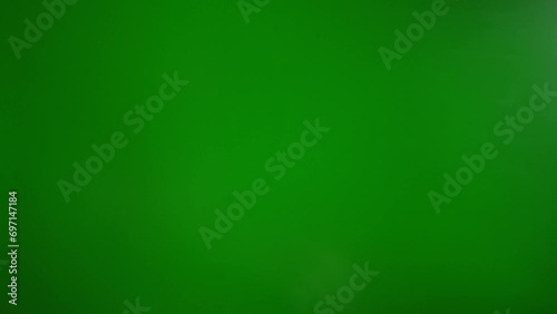 A man makes a fig with his fingers on a green background. The concept of resistance and contempt
